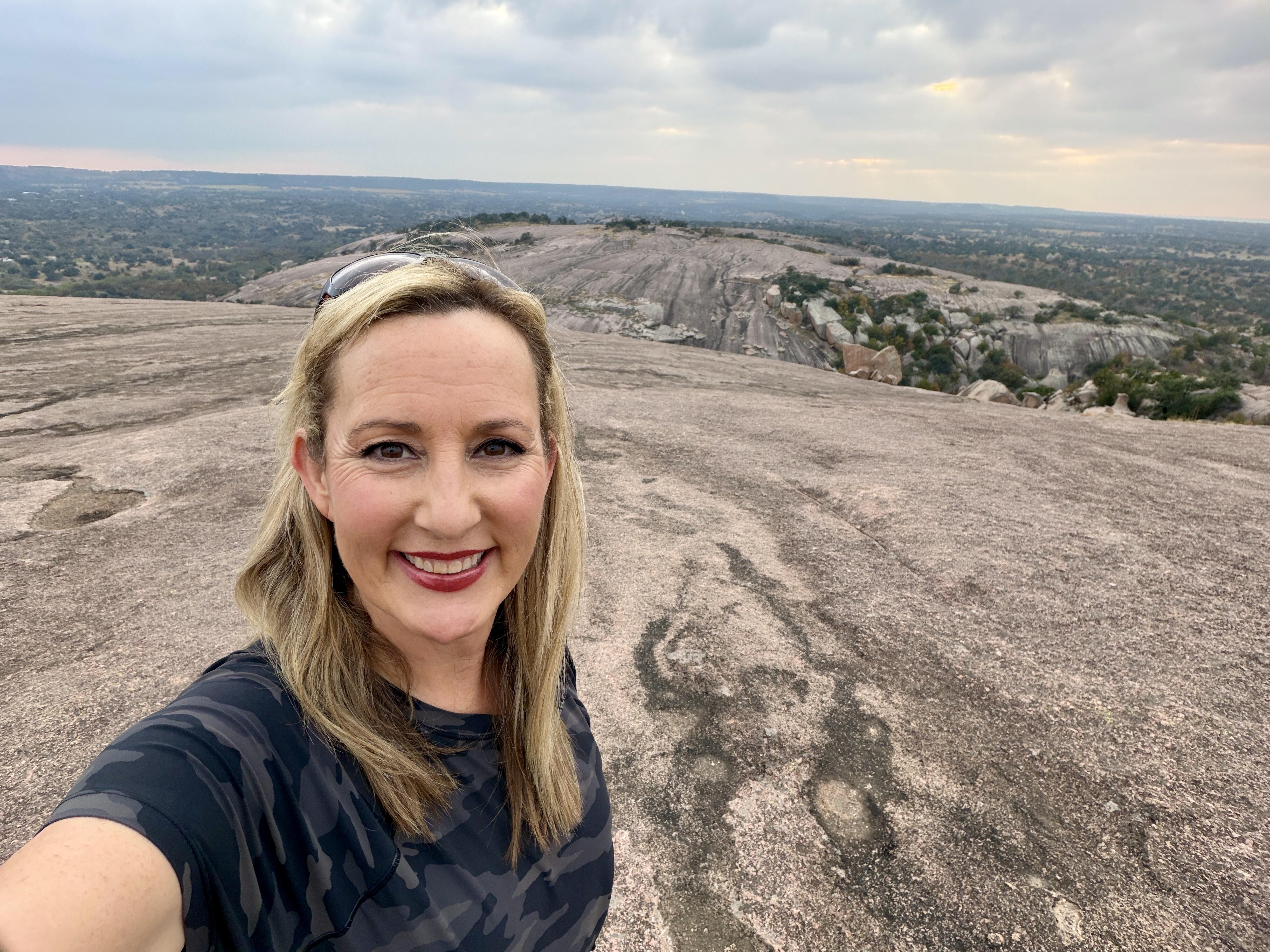 Woman with blond hair on a hike in Enchanted Rock State Natural Area
